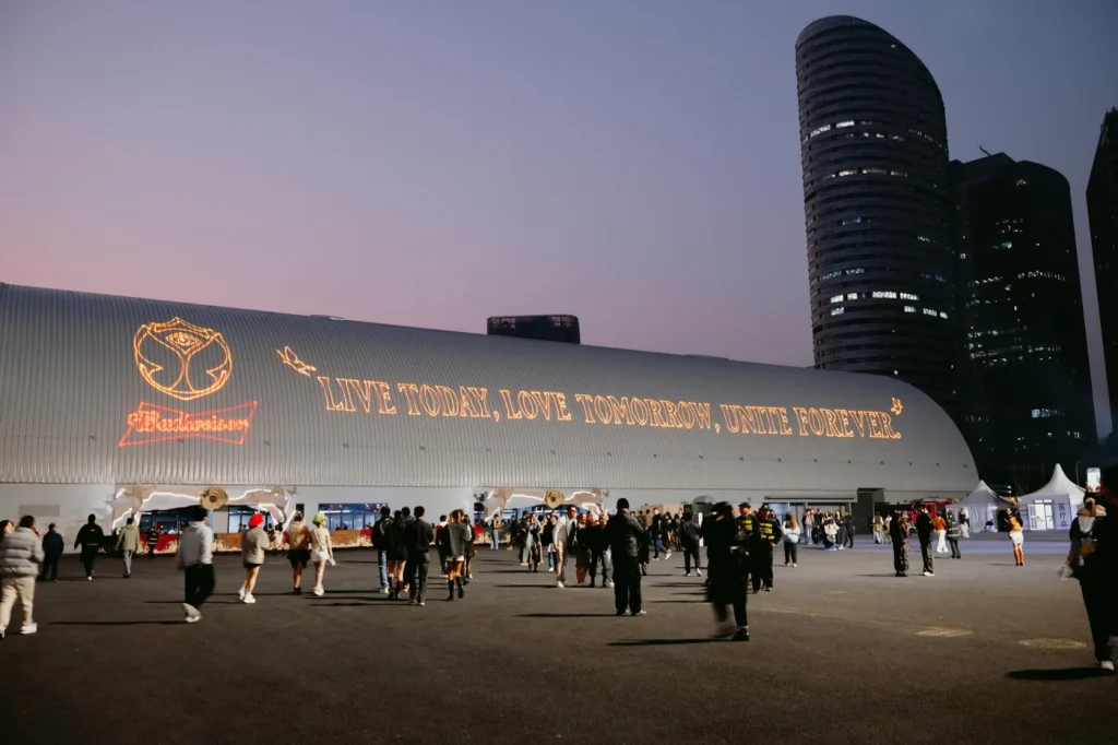 Fachada curva do Hero Dome iluminada com a frase Live Today, Love Tomorrow, Unite Forever, ao anoitecer