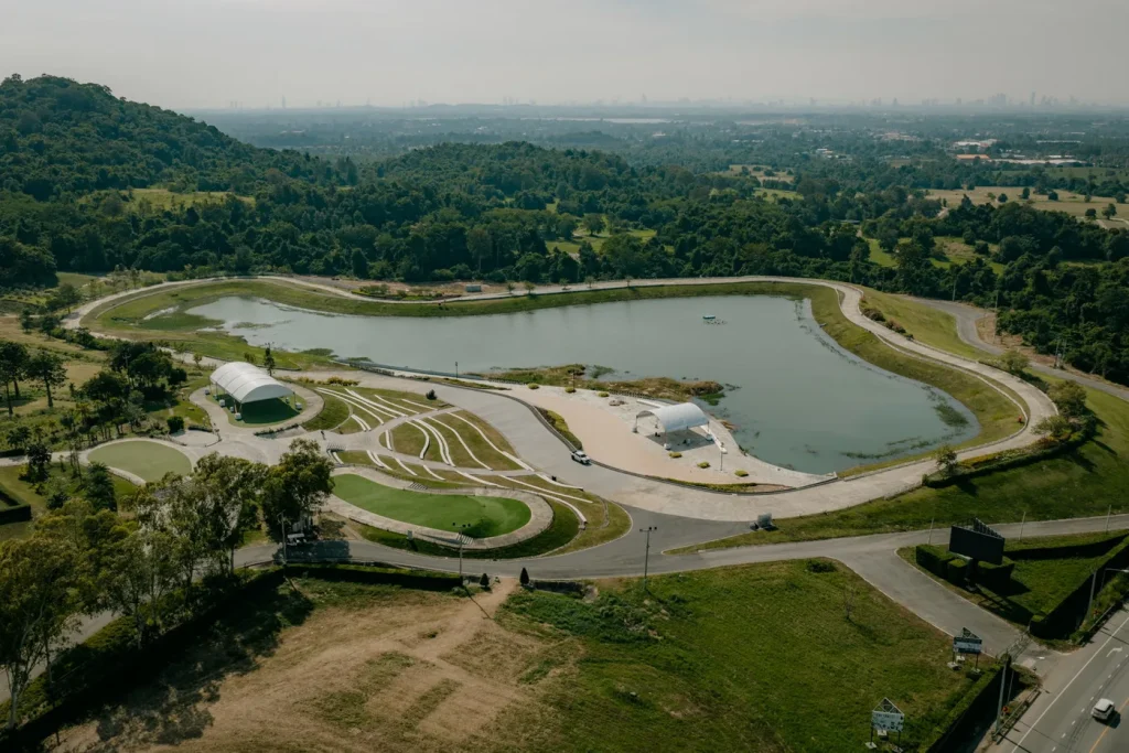 Vista aérea de Wisdom Valley, com lago, vegetação e a cidade ao fundo