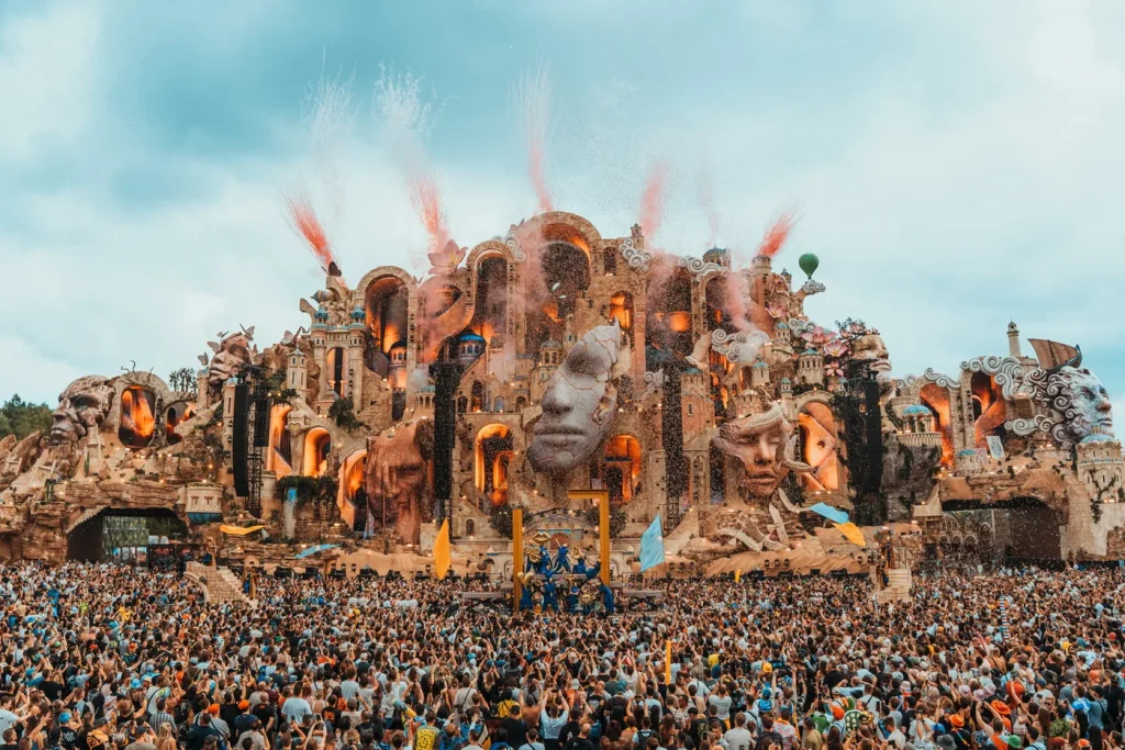 Mainstage do Tomorrowland durante o dia, com confete no ar e o público de braços erguidos