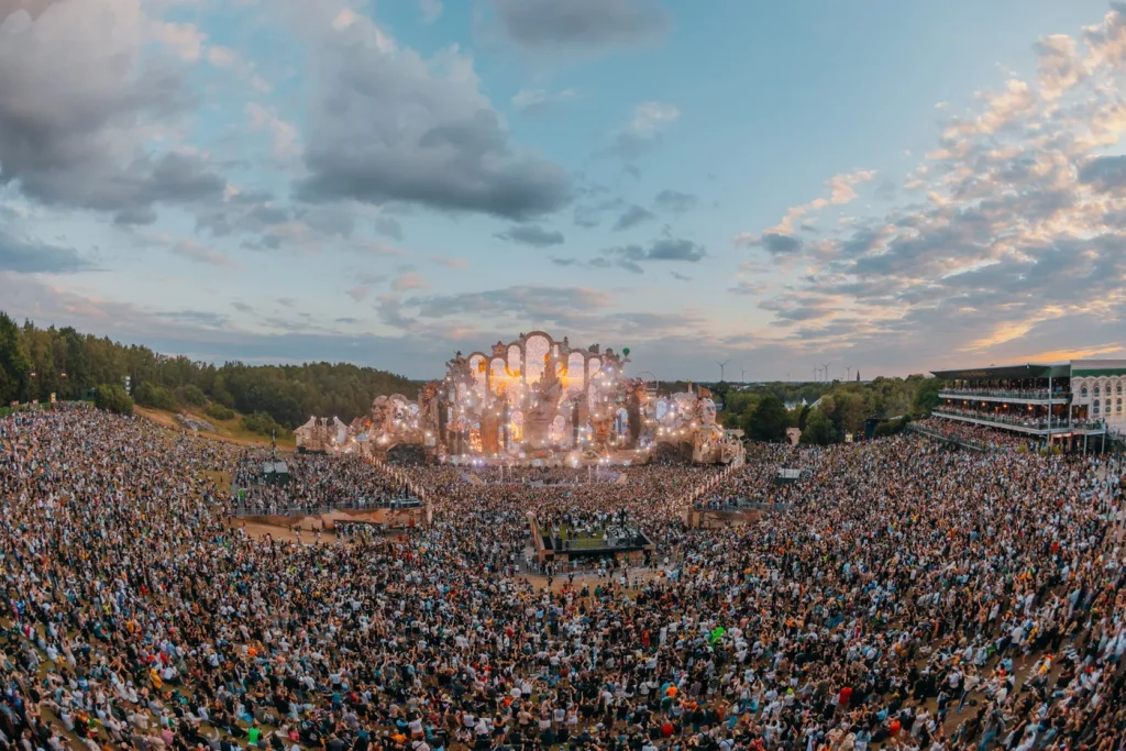 Vista aérea do anfiteatro de De Schorre lotado ao anoitecer, com o mainstage aceso ao fundo