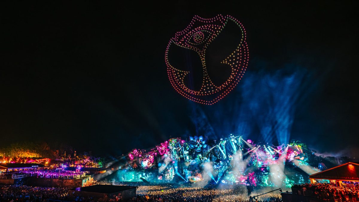 Palco principal do Tomorrowland Brasil iluminado à noite, com luzes sobre o público.